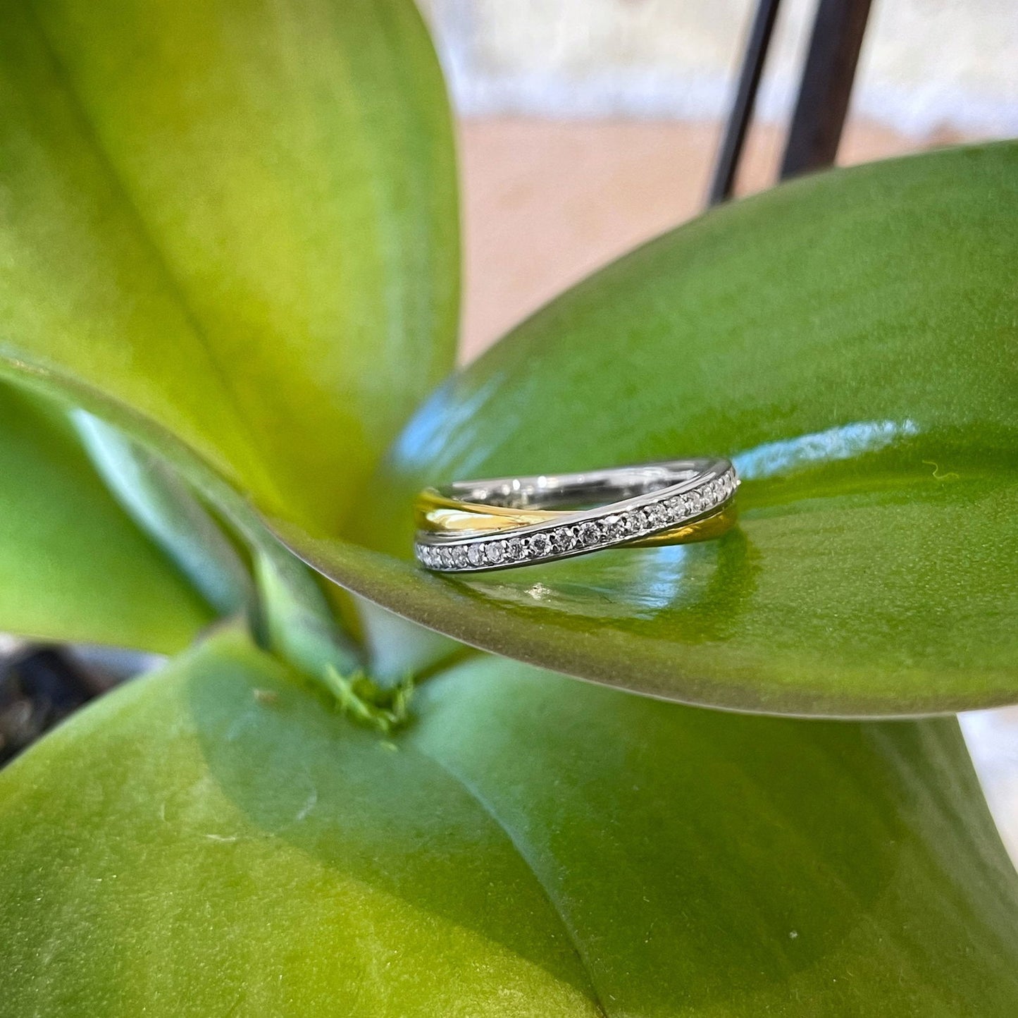 Photo of Cubic Zirconia Twist Ring in a decorative scene, designed by , available at Plumb Gold & Plumb Silver