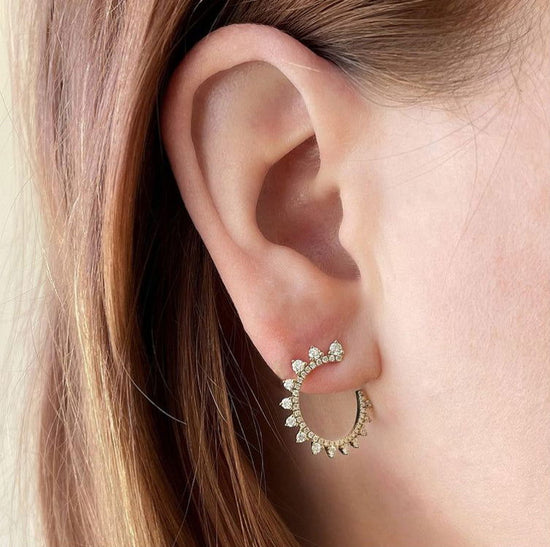 Photo of Curved Diamond Sunburst Wrap Around Earrings in a decorative scene, designed by , available at Plumb Gold & Plumb Silver
