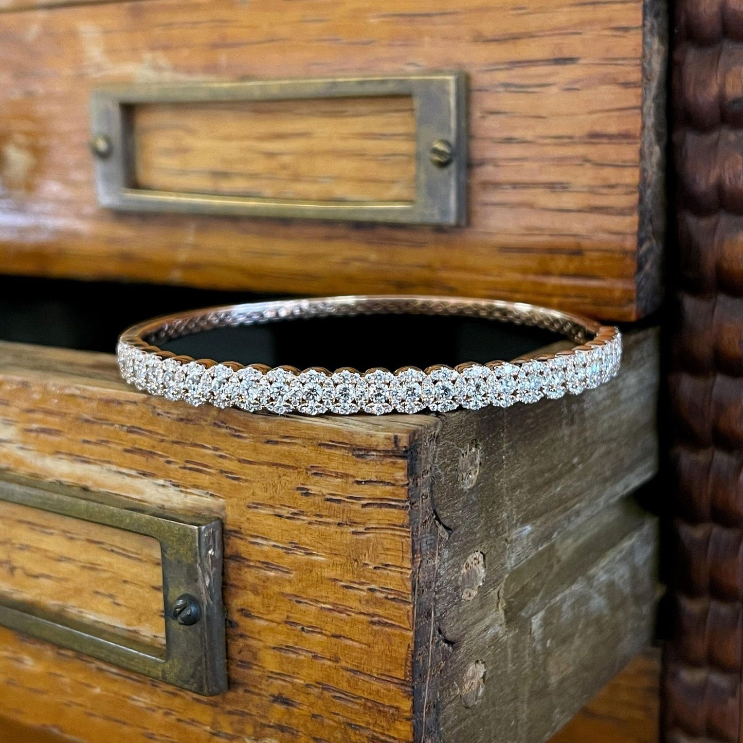 Photo of Diamond Circle Bangle in a decorative scene, designed by , available at Plumb Gold & Plumb Silver