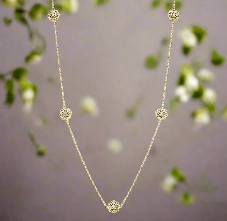Photo of Diamond Flower Station Necklace in a decorative scene, designed by , available at Plumb Gold & Plumb Silver