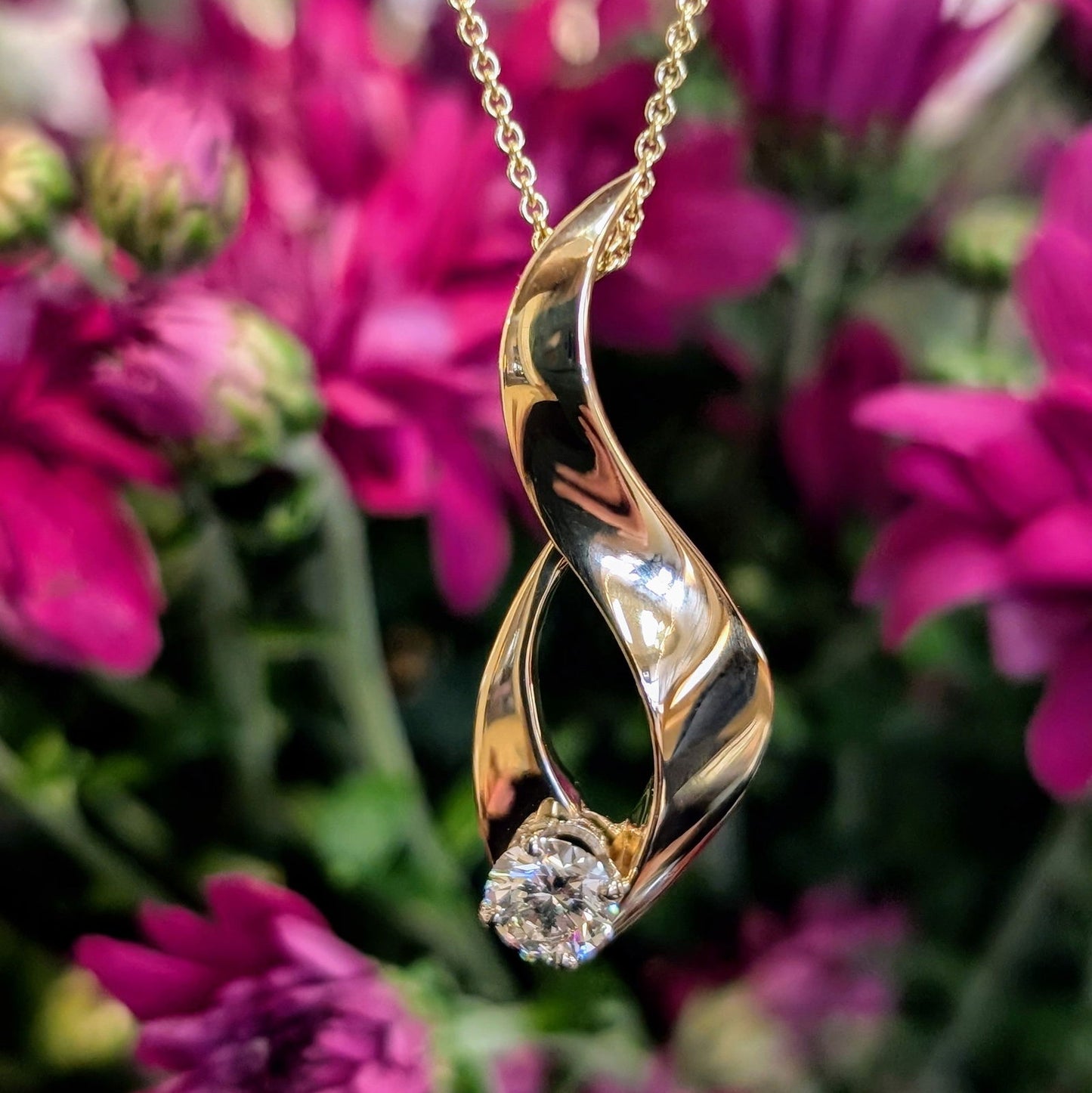 Photo of Diamond Loop Pendant in a decorative scene, designed by -, available at Plumb Gold & Plumb Silver