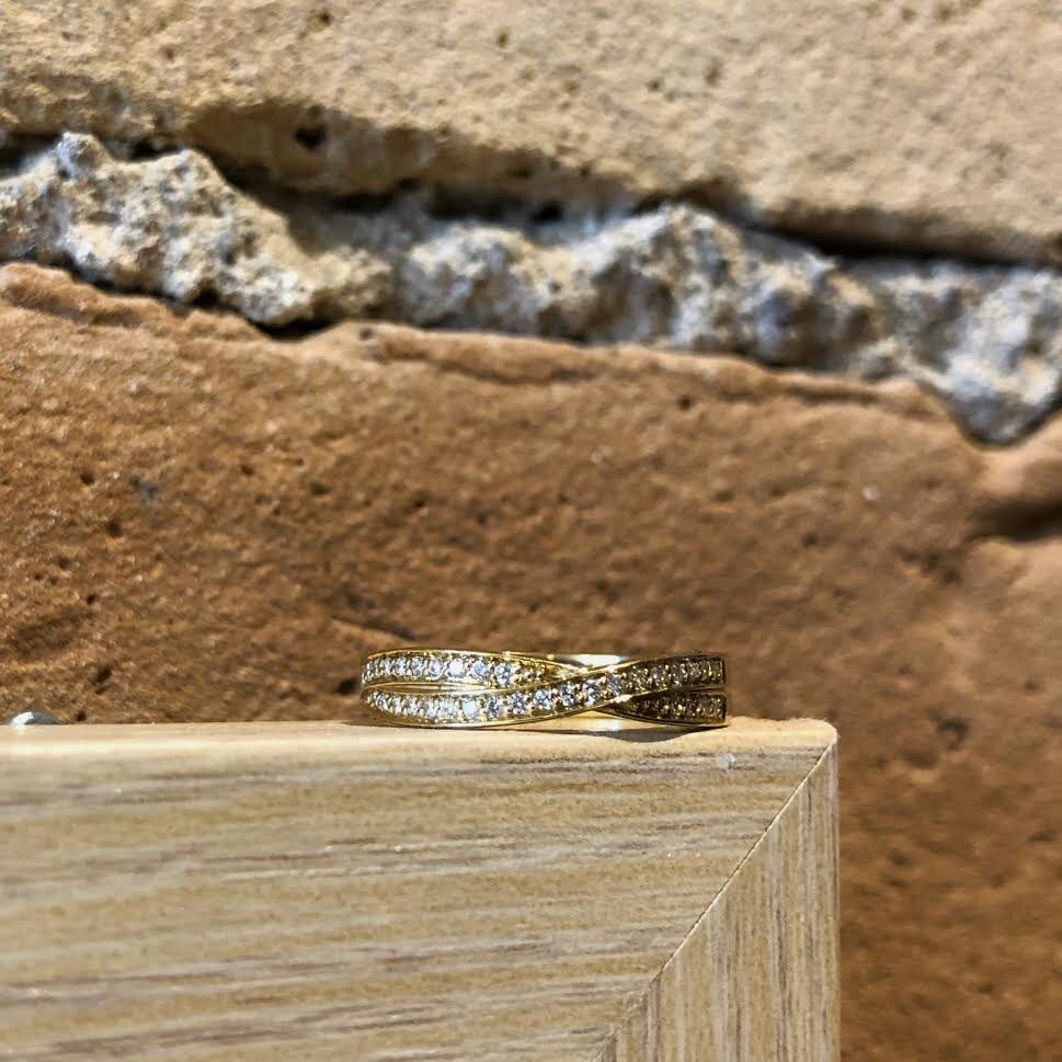 Photo of Diamond Twist Ring in a decorative scene, designed by , available at Plumb Gold & Plumb Silver