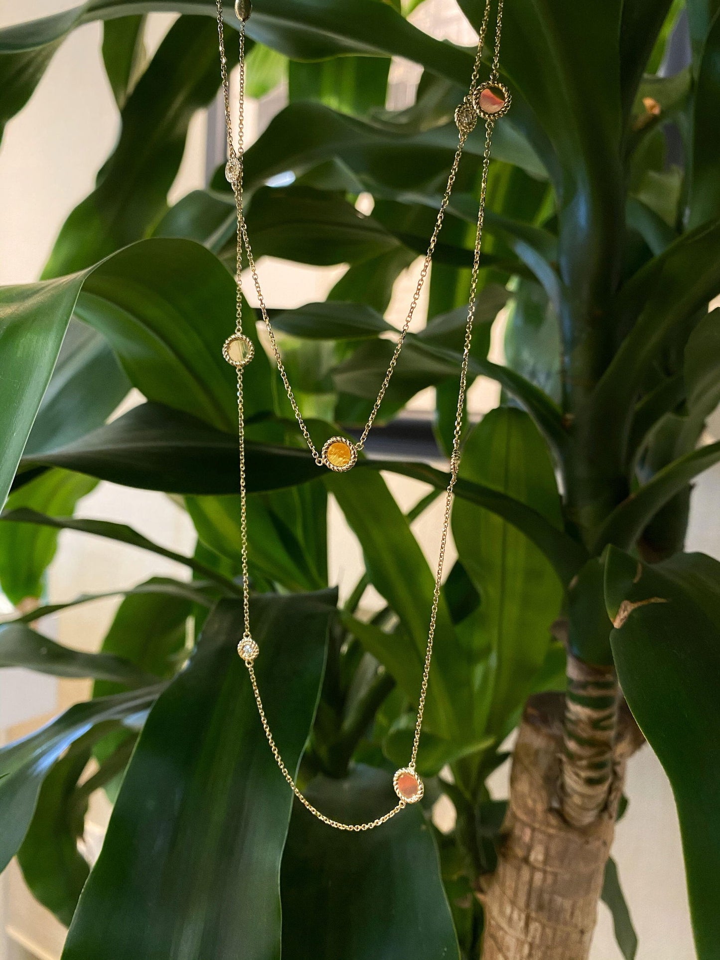 Photo of Disk and Diamond Station Necklace in a decorative scene, designed by , available at Plumb Gold & Plumb Silver