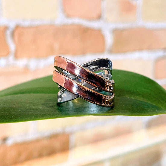Photo of “Double Bridge” Ring in a decorative scene, designed by , available at Plumb Gold & Plumb Silver