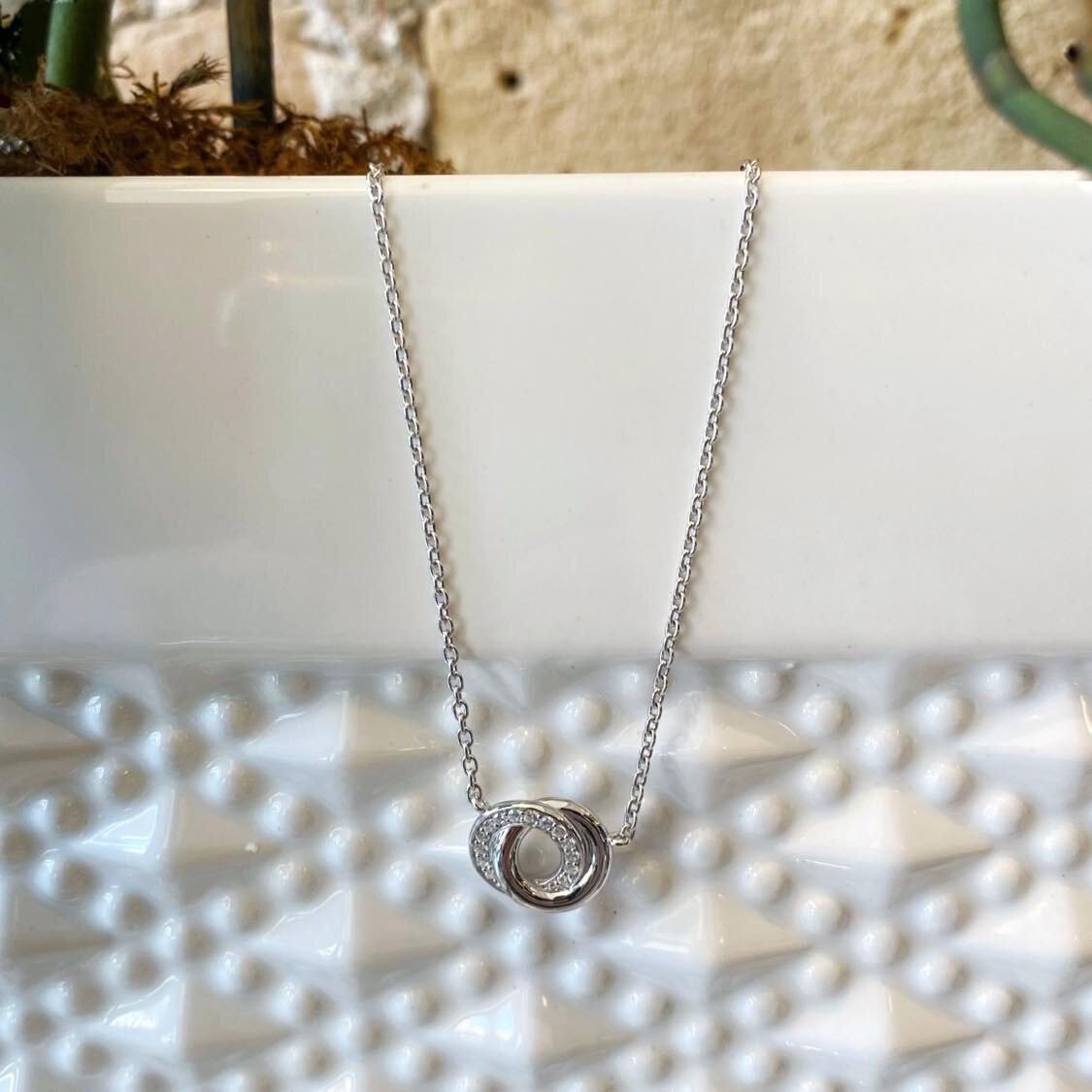 Photo of Double Circle Necklace in a decorative scene, designed by , available at Plumb Gold & Plumb Silver