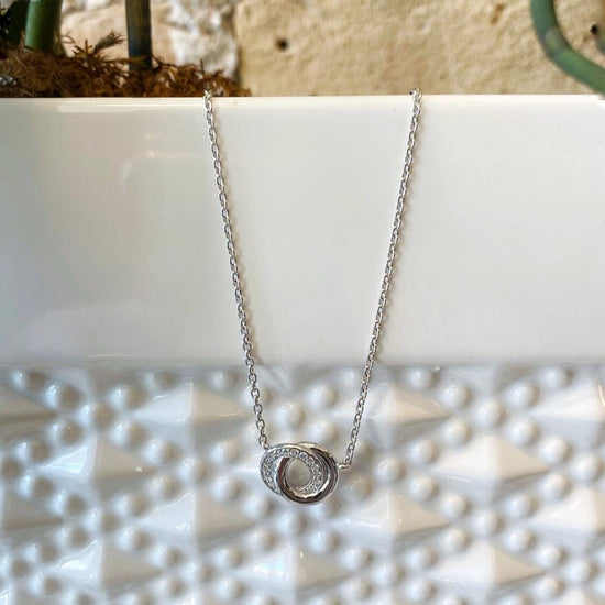Photo of Double Circle Necklace in a decorative scene, designed by , available at Plumb Gold & Plumb Silver