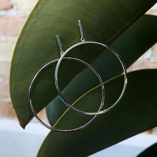 Photo of Dropped Hoop Earring in a decorative scene, designed by , available at Plumb Gold & Plumb Silver