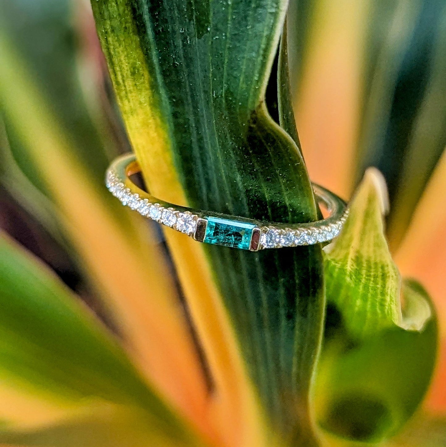 Photo of Emerald baguette stackable ring in a decorative scene, designed by , available at Plumb Gold & Plumb Silver