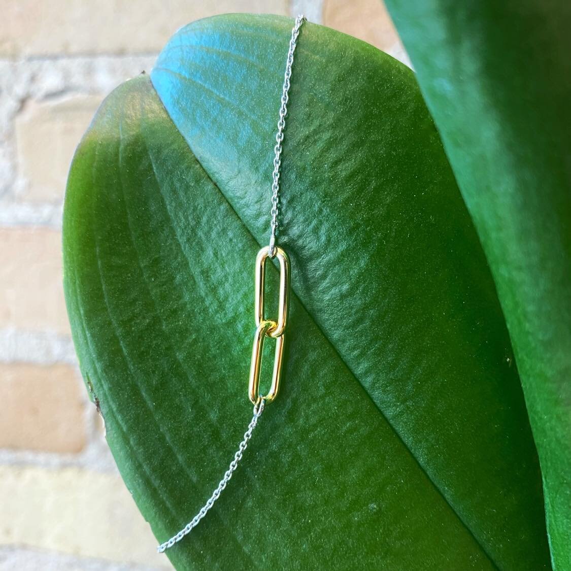 Photo of Entwined Paperclip Bracelet in a decorative scene, designed by , available at Plumb Gold & Plumb Silver