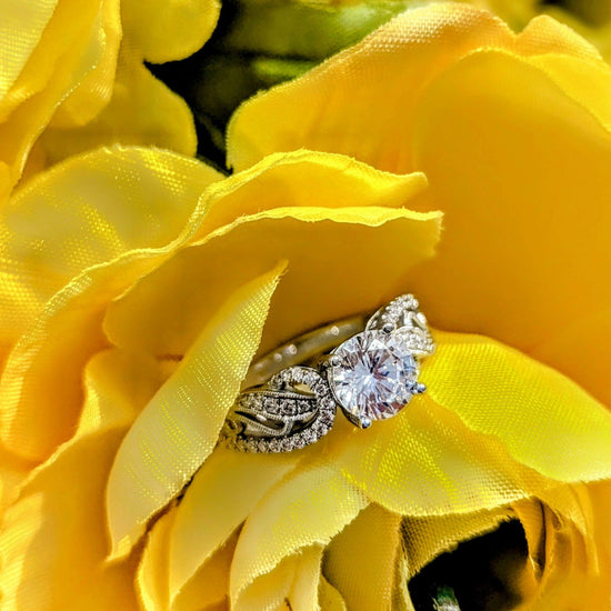 Photo of "Estella" Filigree Swirl Engagement Ring in a decorative scene, designed by , available at Plumb Gold & Plumb Silver