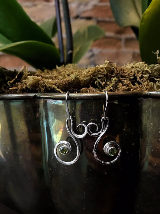 Photo of "Fiddlehead" Earrings in a decorative scene, designed by , available at Plumb Gold & Plumb Silver