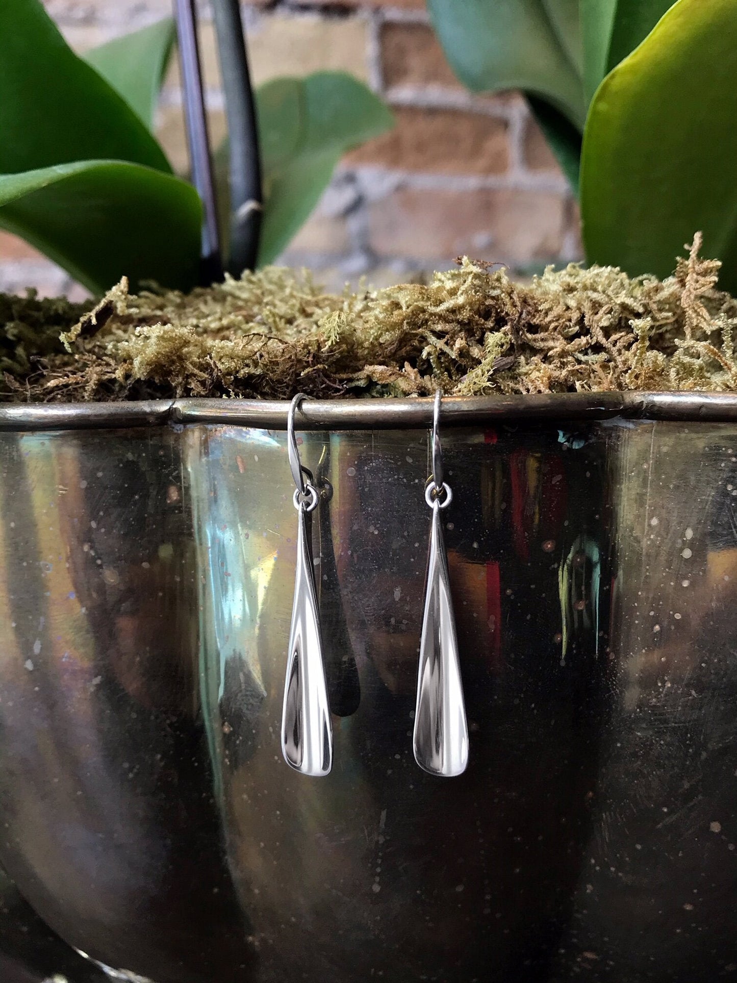 Photo of "Flume" Earrings in a decorative scene, designed by , available at Plumb Gold & Plumb Silver