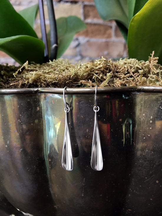 Photo of "Flume" Earrings in a decorative scene, designed by , available at Plumb Gold & Plumb Silver