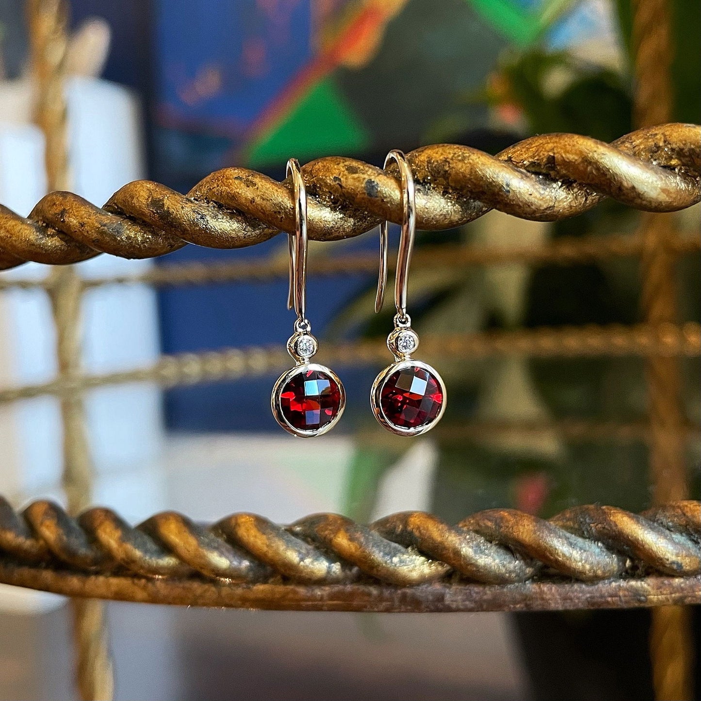 Photo of Garnet and Diamond Dangles in a decorative scene, designed by , available at Plumb Gold & Plumb Silver