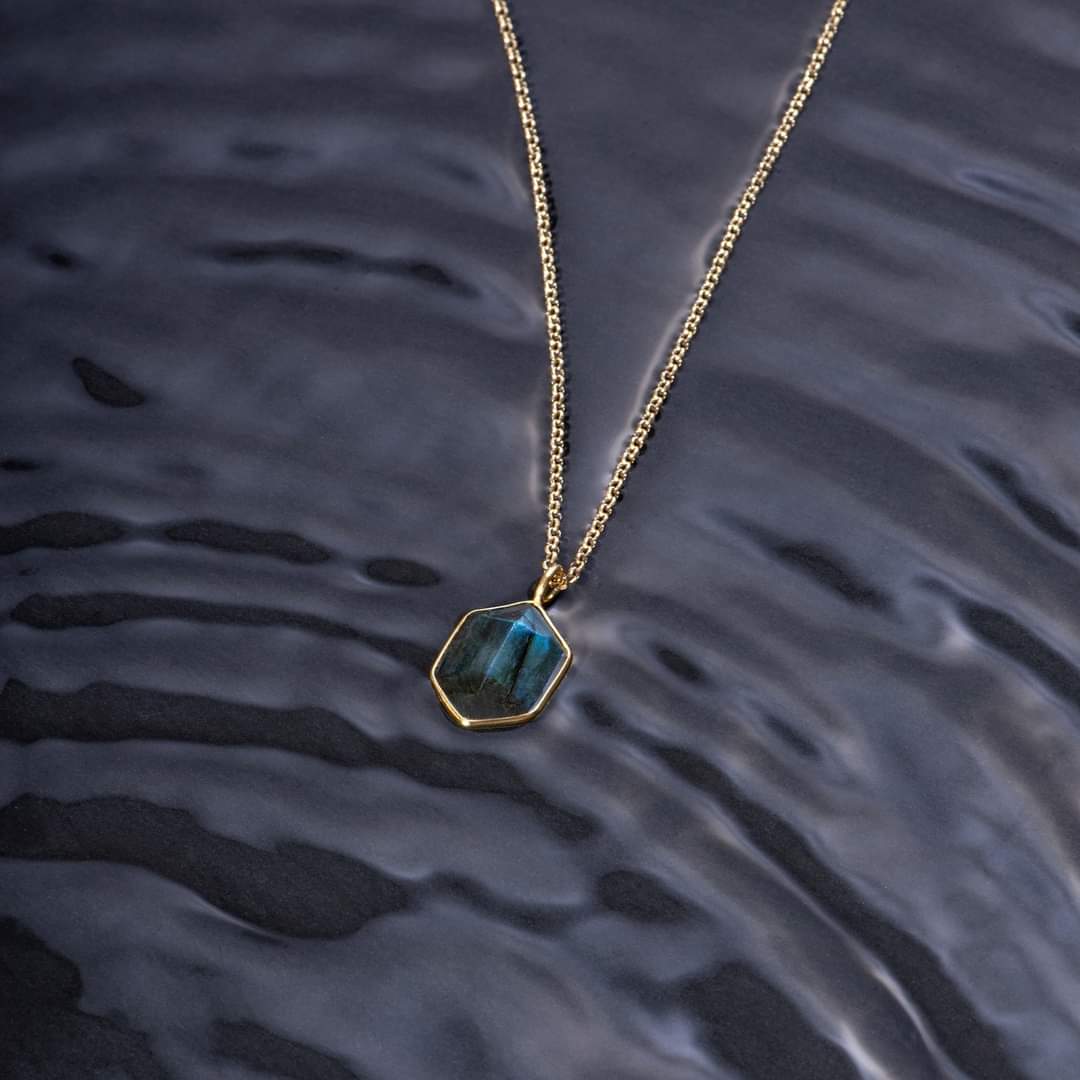 Photo of “Geo” Labradorite Pendant in a decorative scene, designed by , available at Plumb Gold & Plumb Silver