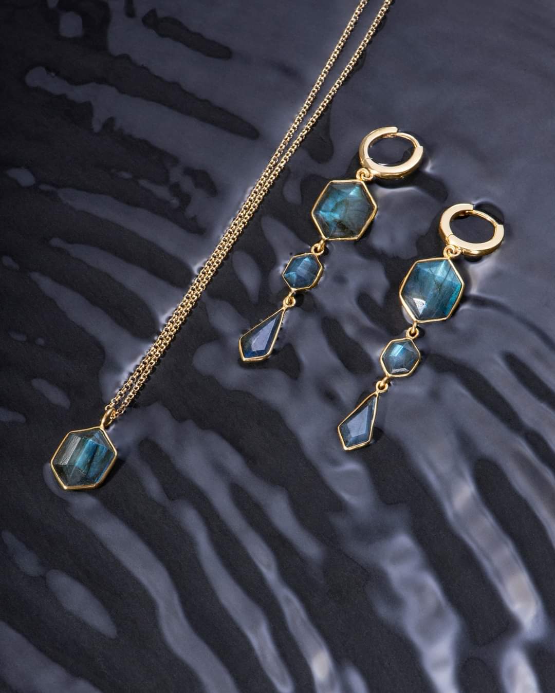 Photo of “Geo” Labradorite Pendant in a decorative scene, designed by , available at Plumb Gold & Plumb Silver