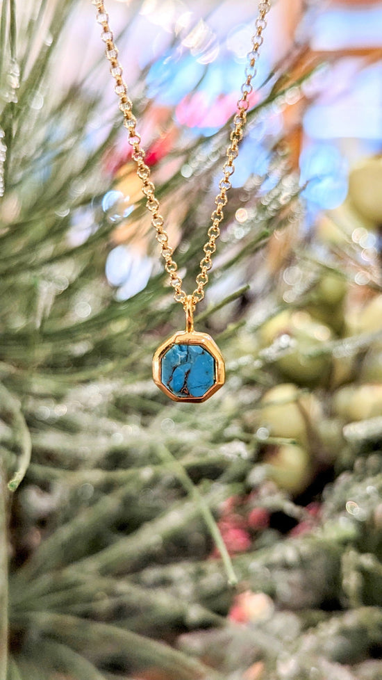 Photo of "Geo" Turquoise Pendant in a decorative scene, designed by , available at Plumb Gold & Plumb Silver