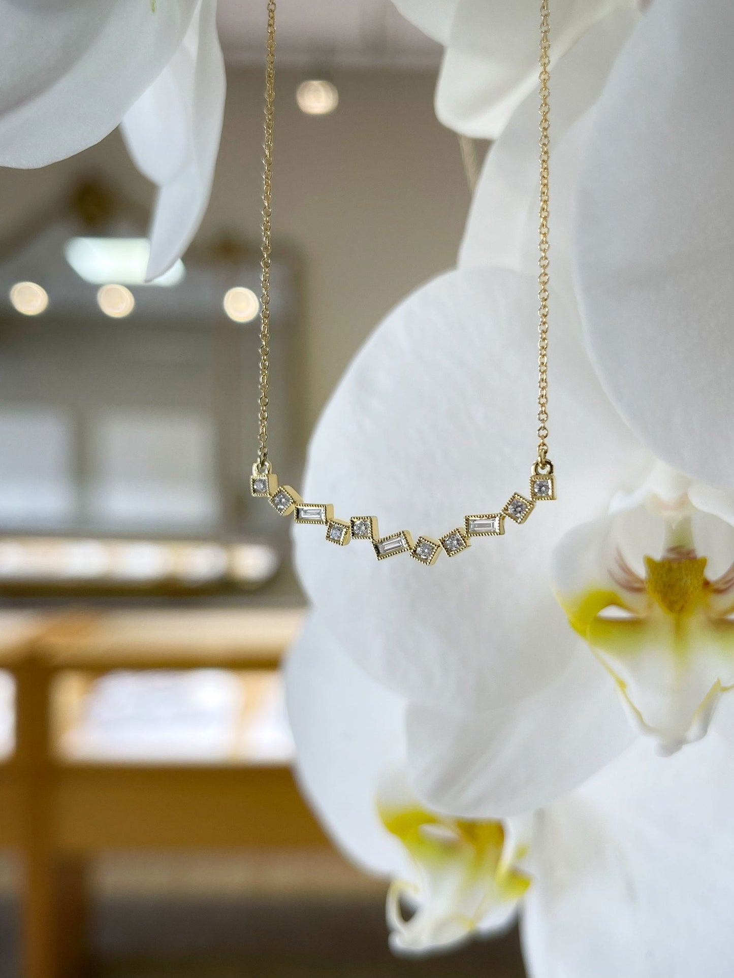Photo of Geometric Diamond Necklace in a decorative scene, designed by , available at Plumb Gold & Plumb Silver