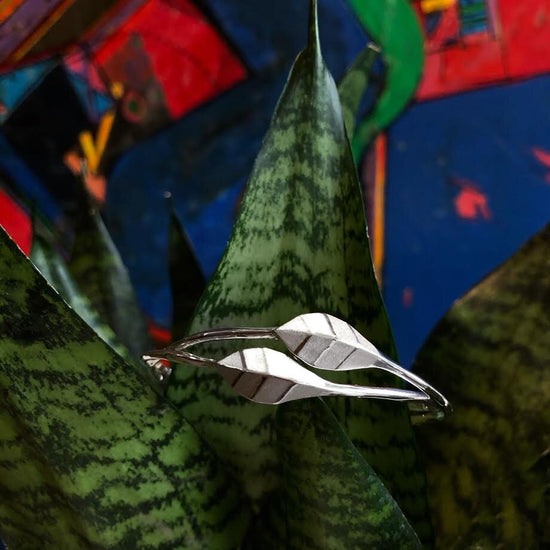 Photo of "Geometric" Leaf Cuff Bracelet in a decorative scene, designed by , available at Plumb Gold & Plumb Silver