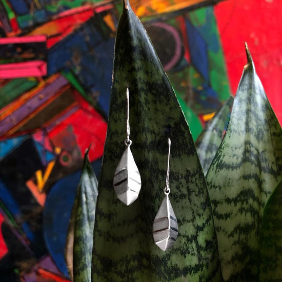 Photo of "Geometric" Leaf Earring in a decorative scene, designed by , available at Plumb Gold & Plumb Silver