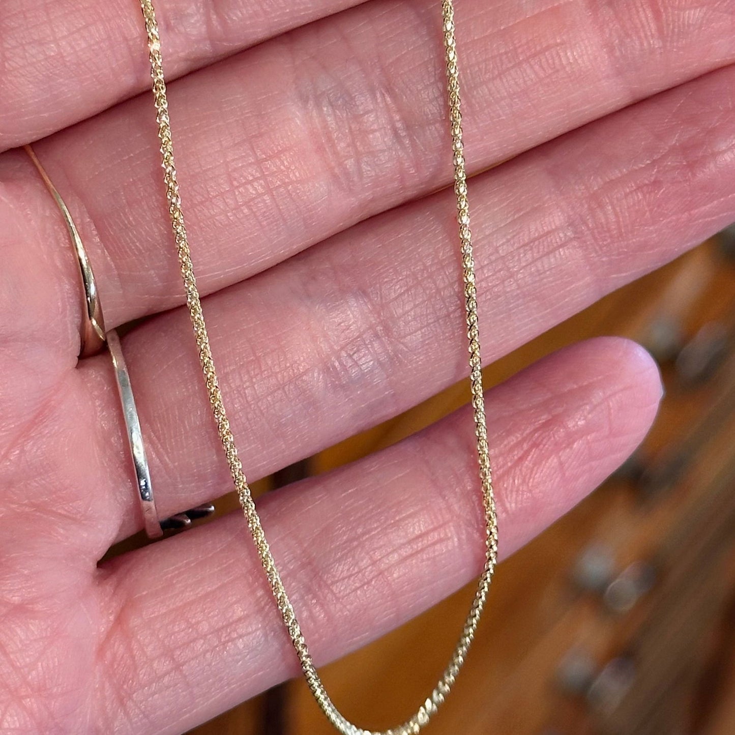 Photo of Gold Diamond Cut Wheat Chain in a decorative scene, designed by , available at Plumb Gold & Plumb Silver