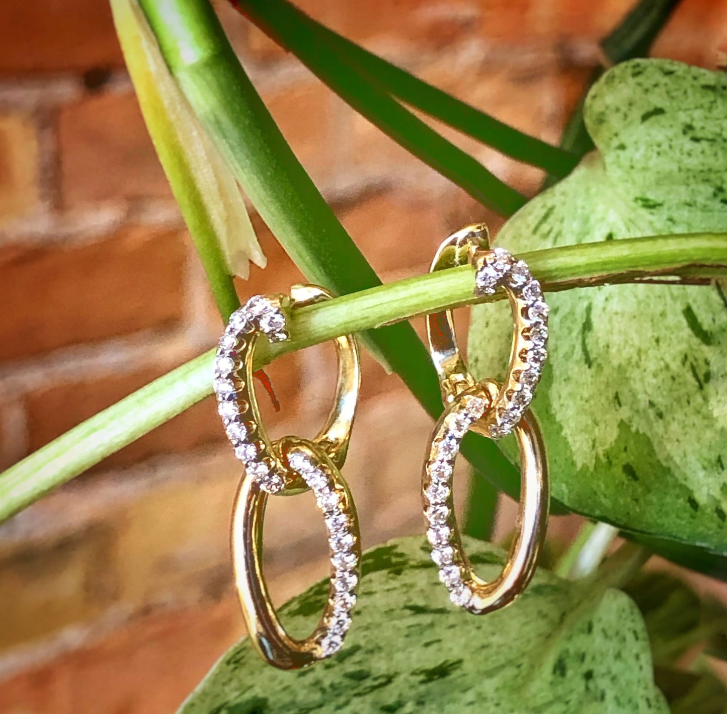 Photo of Gold and Diamond Links Drop Earrings in a decorative scene, designed by , available at Plumb Gold & Plumb Silver