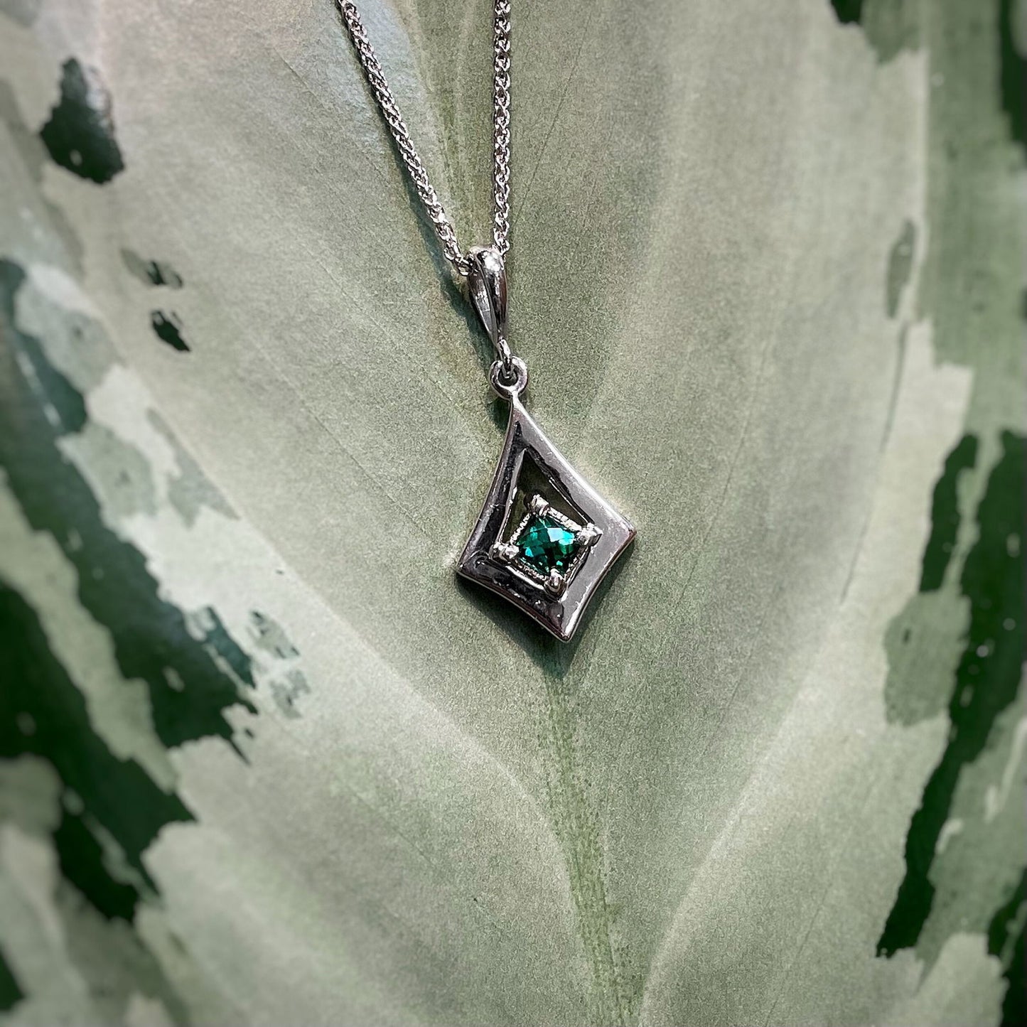 Photo of Green Tourmaline Pendant in a decorative scene, designed by , available at Plumb Gold & Plumb Silver