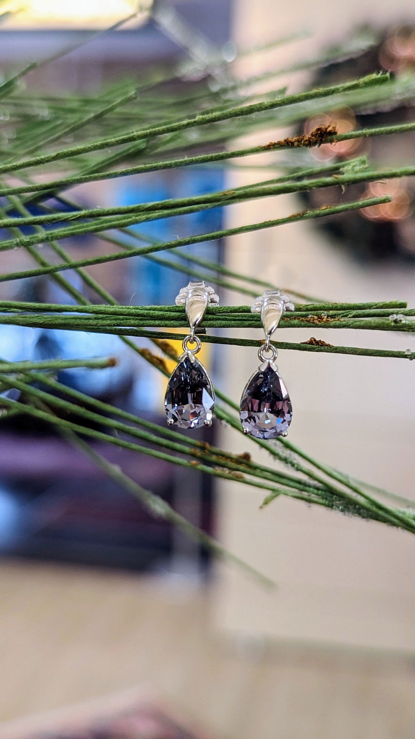 Photo of Grey Spinel Dangle Earrings in a decorative scene, designed by , available at Plumb Gold & Plumb Silver