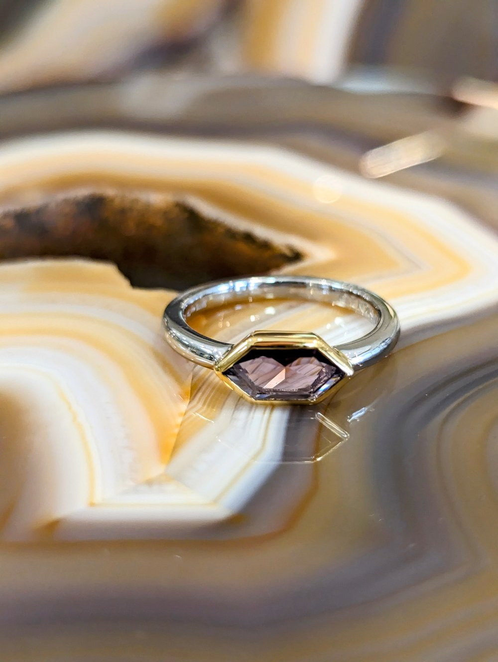 Photo of Hexagon Bezel Ring in a decorative scene, designed by , available at Plumb Gold & Plumb Silver