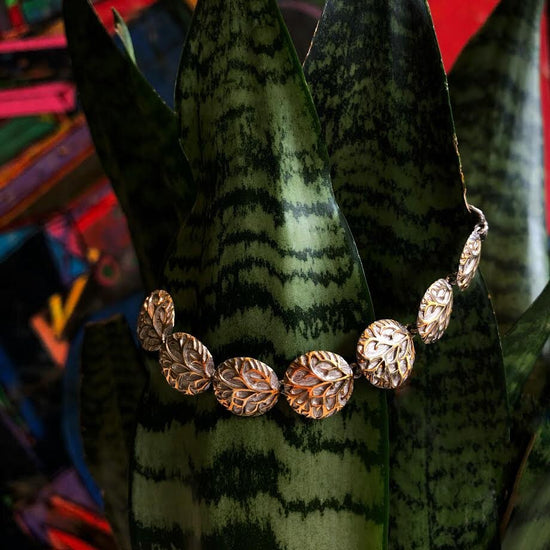 Photo of "Hiedra" Link Bracelet in a decorative scene, designed by , available at Plumb Gold & Plumb Silver