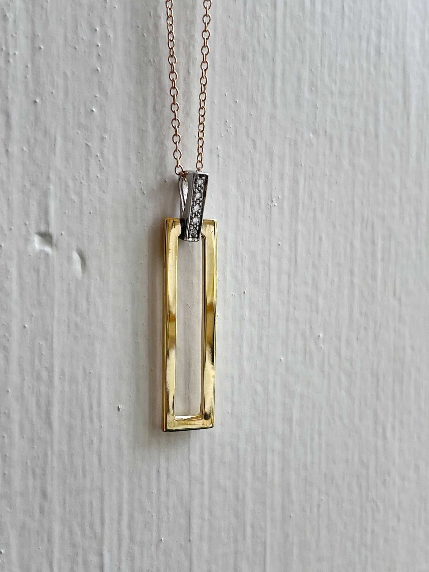 Photo of I.Reiss Open Rectangle Necklace in a decorative scene, designed by , available at Plumb Gold & Plumb Silver