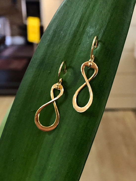 Photo of Infinity Dangles in a decorative scene, designed by , available at Plumb Gold & Plumb Silver