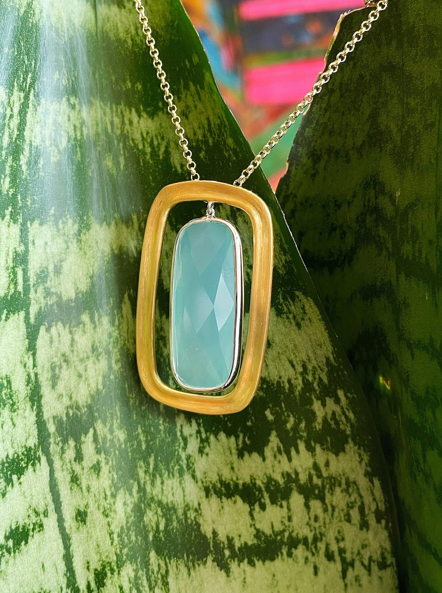 Photo of "Keops" Chalcedony Pendant in a decorative scene, designed by , available at Plumb Gold & Plumb Silver