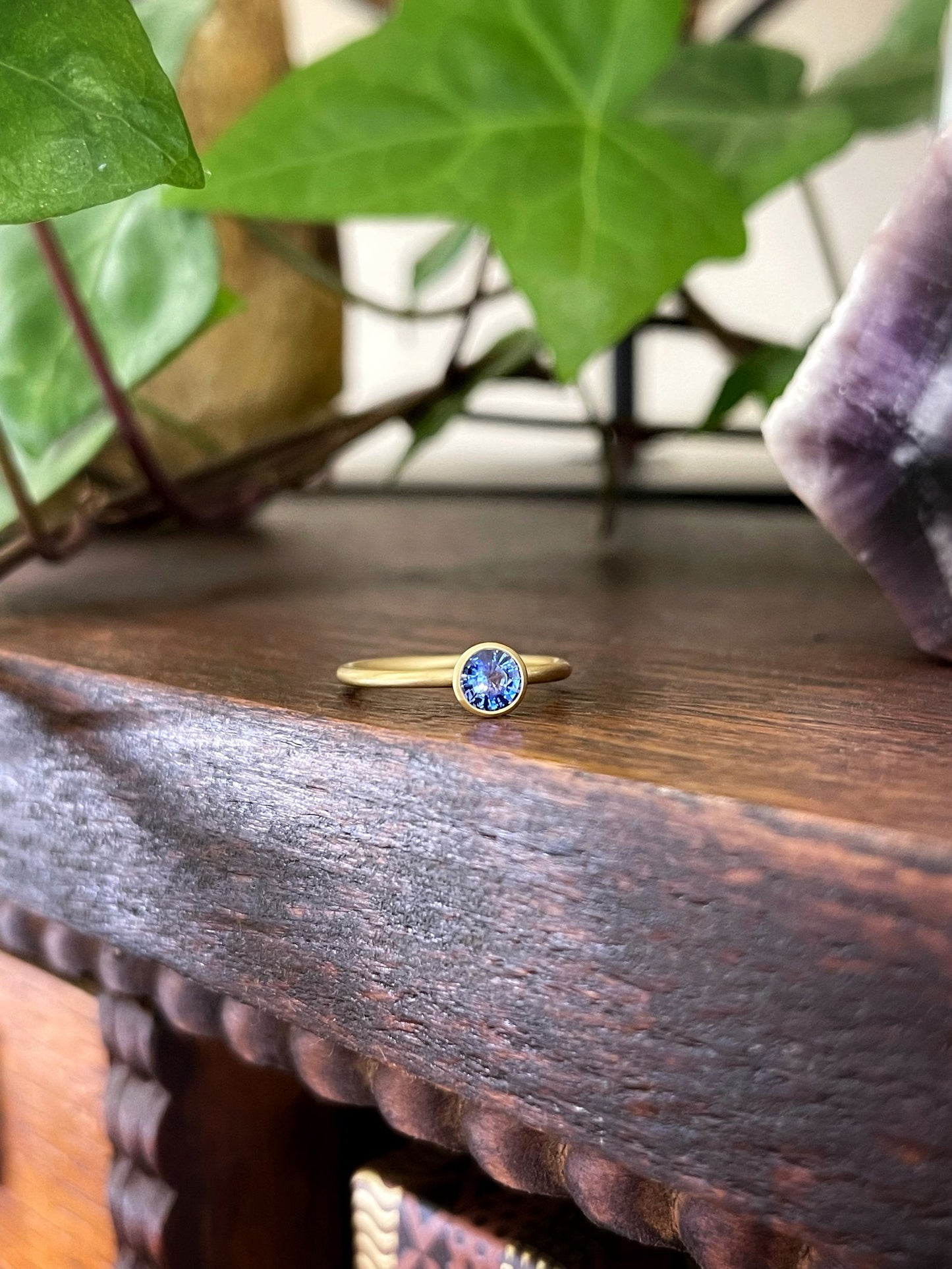 Photo of Kim Collins Blue Sapphire Yumdrop in a decorative scene, designed by , available at Plumb Gold & Plumb Silver
