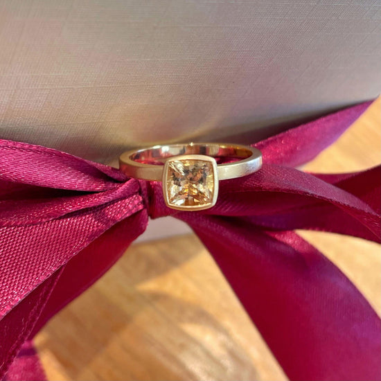 Photo of Kim Collins Danburite Yum Drop Ring in a decorative scene, designed by , available at Plumb Gold & Plumb Silver