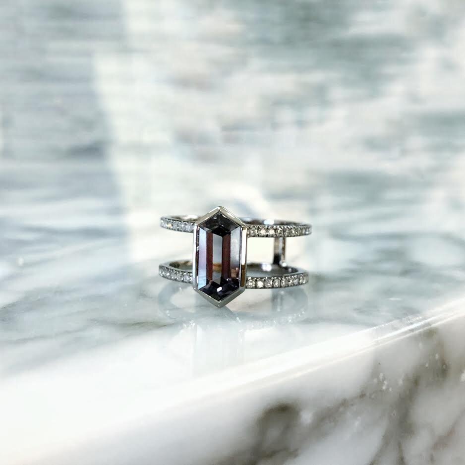 Photo of Kim Collins Hexagon Gray Spinel Ring in a decorative scene, designed by , available at Plumb Gold & Plumb Silver
