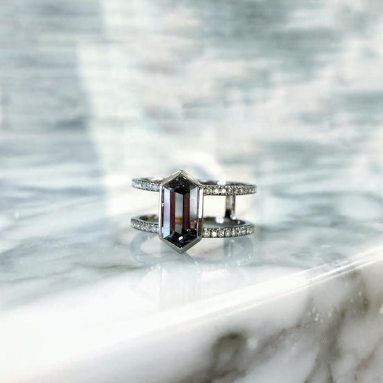 Photo of Kim Collins Hexagon Gray Spinel Ring in a decorative scene, designed by , available at Plumb Gold & Plumb Silver