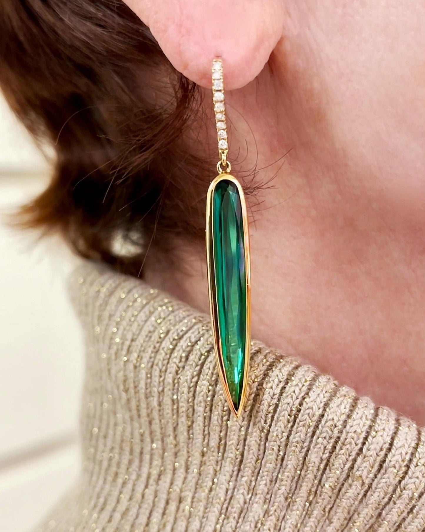 Photo of Kimberly Collins Green Tourmaline "Spike" Dangle in a decorative scene, designed by , available at Plumb Gold & Plumb Silver