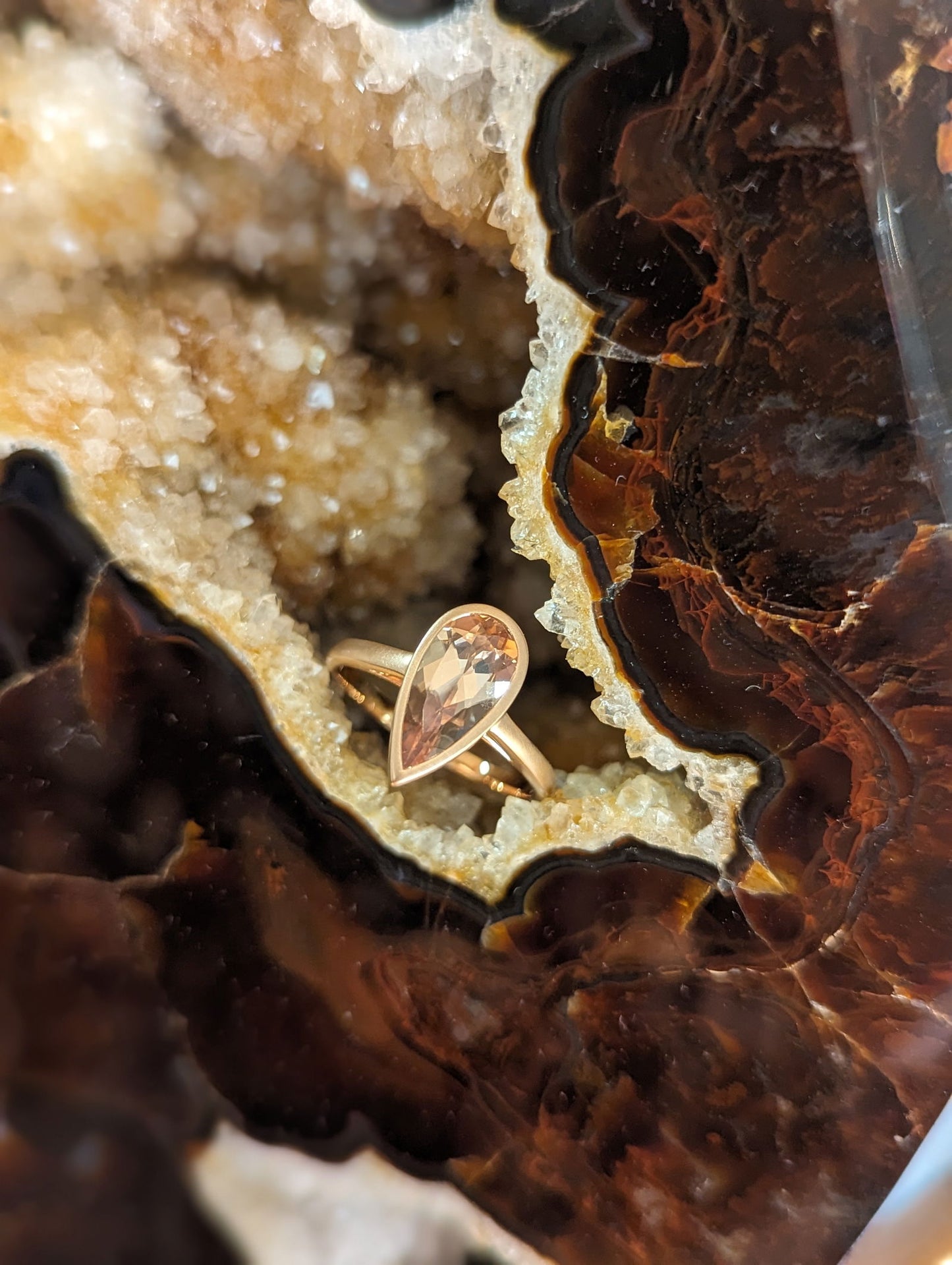 Photo of Kimberly Collins Spice Zircon Bezel Ring in a decorative scene, designed by , available at Plumb Gold & Plumb Silver