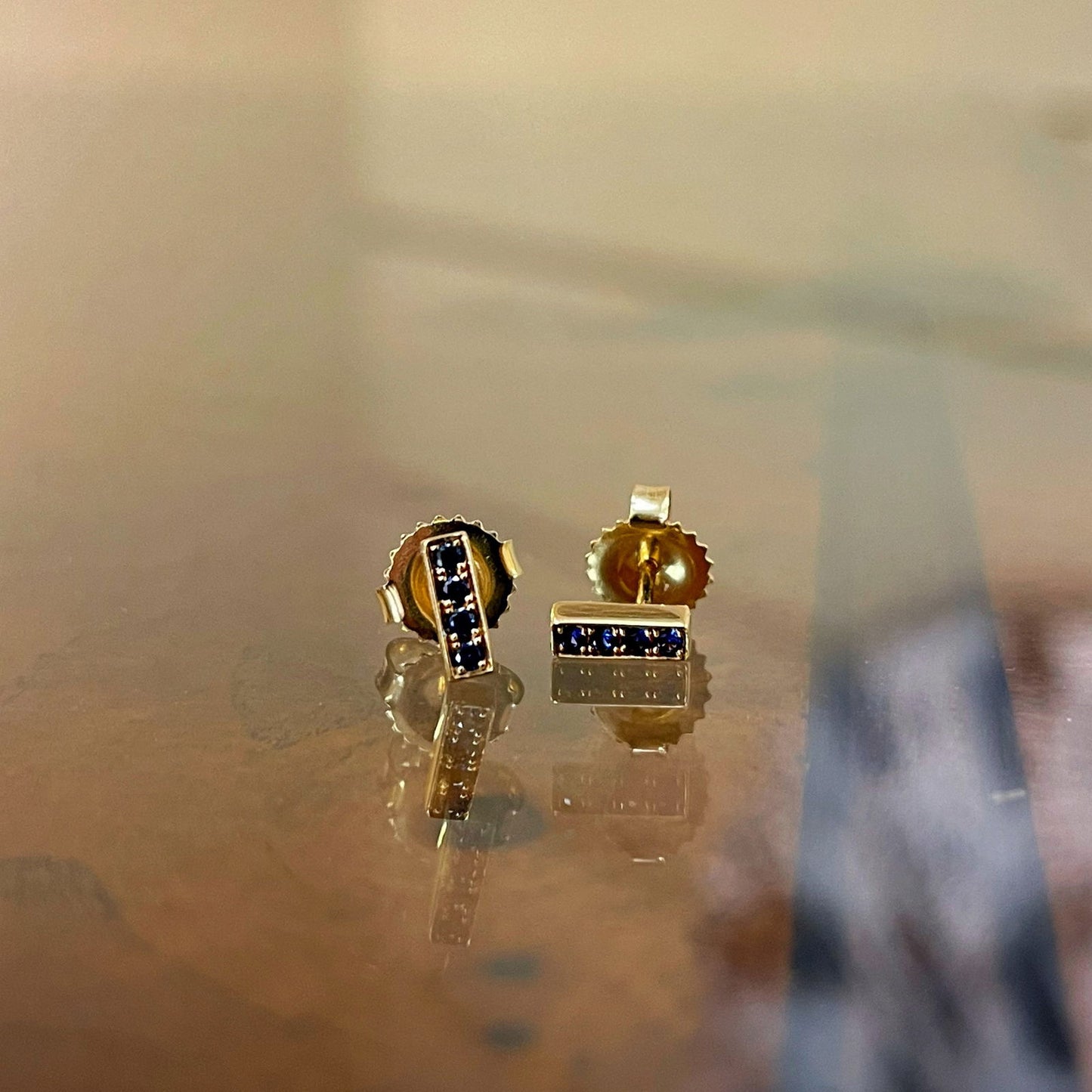 Photo of Kimberly Collins Stick Studs in a decorative scene, designed by , available at Plumb Gold & Plumb Silver