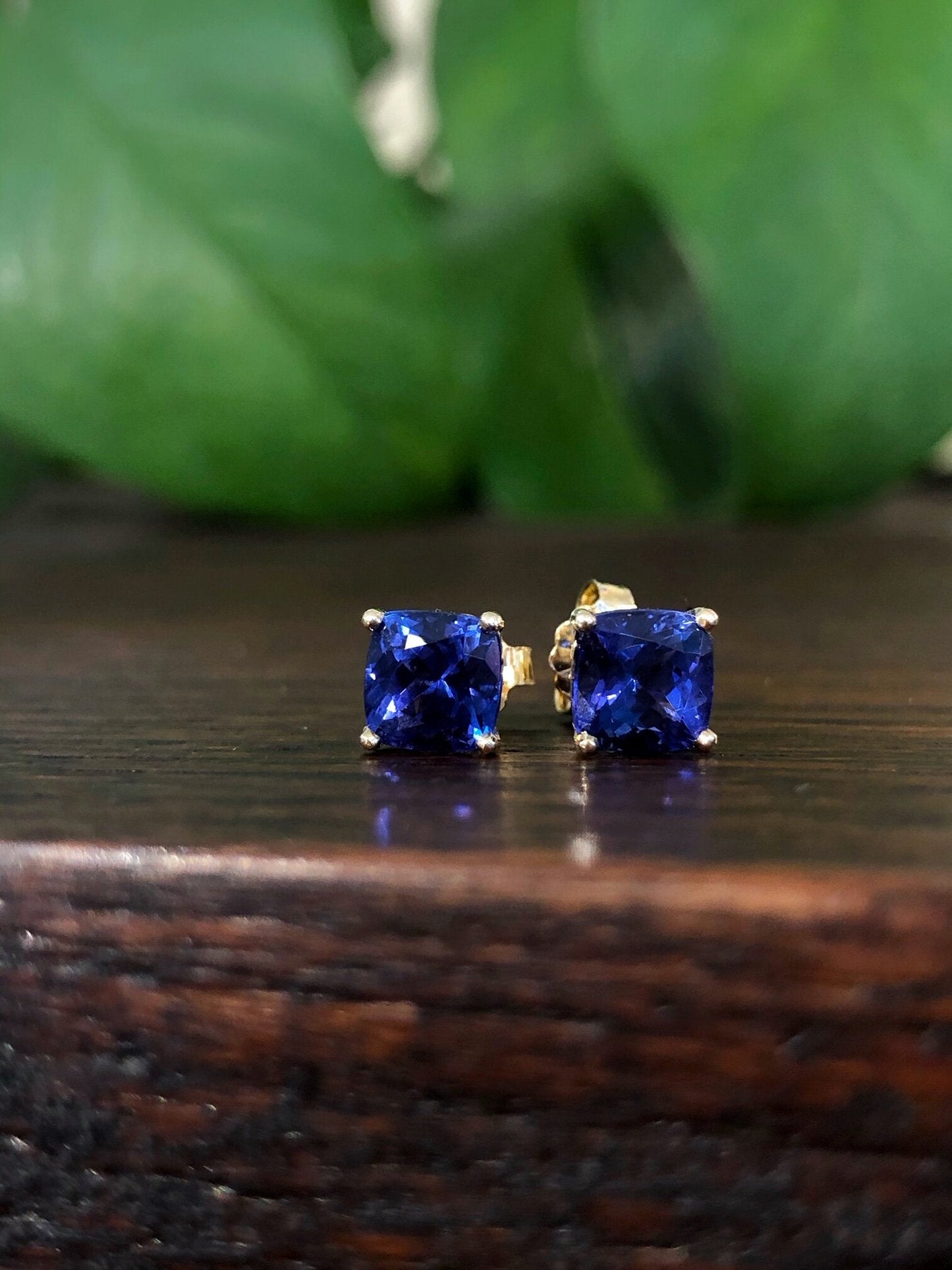 Photo of Kimberly Collins Tanzanite Studs in a decorative scene, designed by , available at Plumb Gold & Plumb Silver