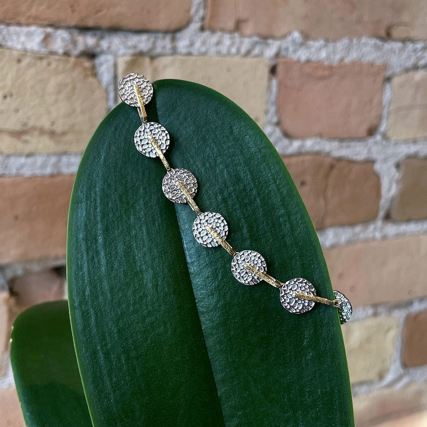 Photo of “Kymbal” Bracelet in a decorative scene, designed by , available at Plumb Gold & Plumb Silver