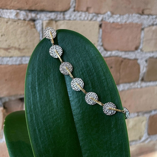 Photo of “Kymbal” Bracelet in a decorative scene, designed by , available at Plumb Gold & Plumb Silver