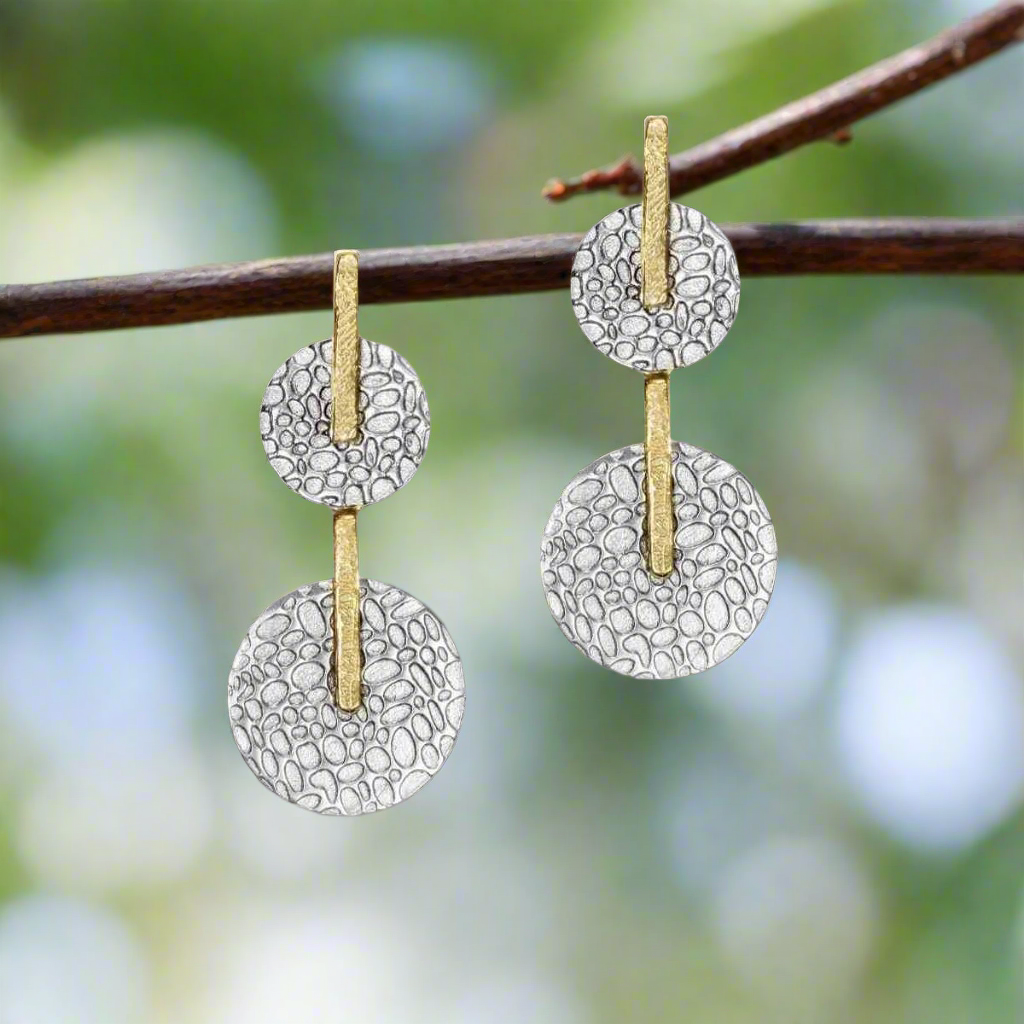 Photo of "Kymbal" Drop Earring in a decorative scene, designed by -, available at Plumb Gold & Plumb Silver