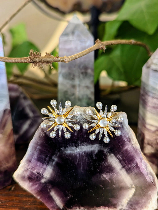 Photo of Large Celestial Stud Earrings in a decorative scene, designed by , available at Plumb Gold & Plumb Silver