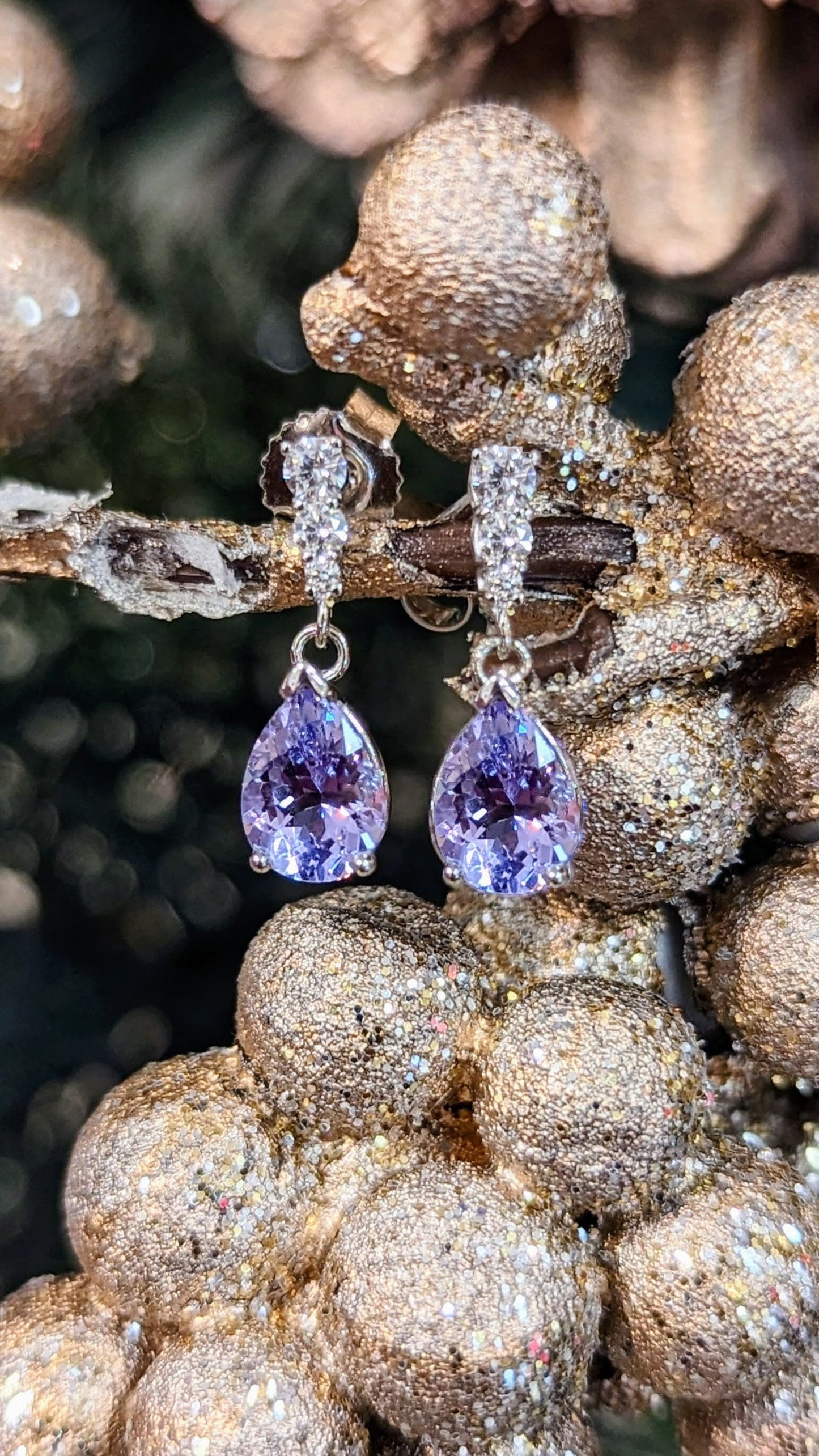 Photo of Lavender Spinel Diamond Accented Dangles in a decorative scene, designed by , available at Plumb Gold & Plumb Silver