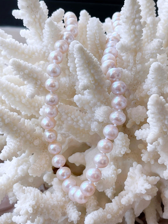 Photo of Light Pink Pearl Strand in a decorative scene, designed by , available at Plumb Gold & Plumb Silver