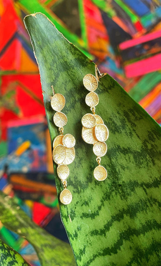 Photo of "Lily" Dangle Earrings in a decorative scene, designed by , available at Plumb Gold & Plumb Silver