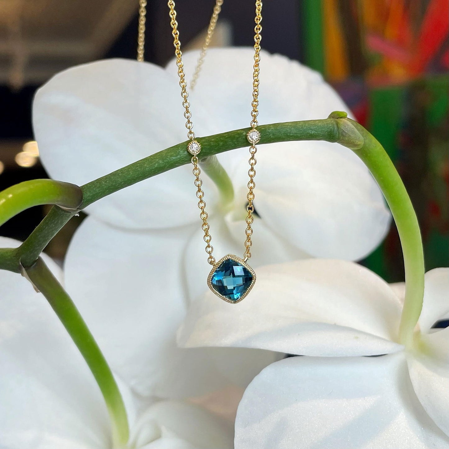 Photo of London Blue Topaz Necklace in a decorative scene, designed by , available at Plumb Gold & Plumb Silver