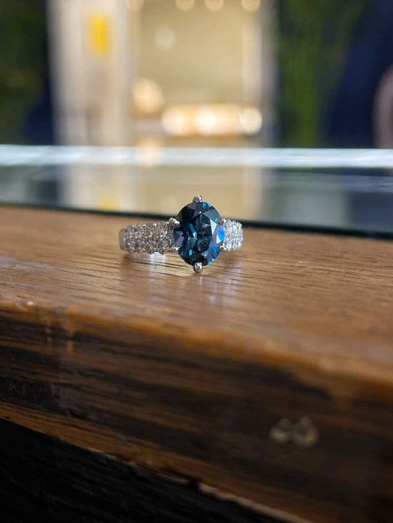 Photo of London Blue Topaz Ring in a decorative scene, designed by , available at Plumb Gold & Plumb Silver